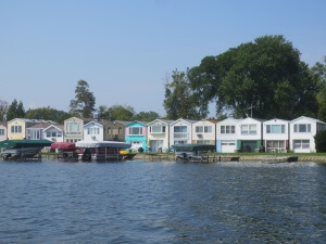Tightly packed homes and boathouse with lake